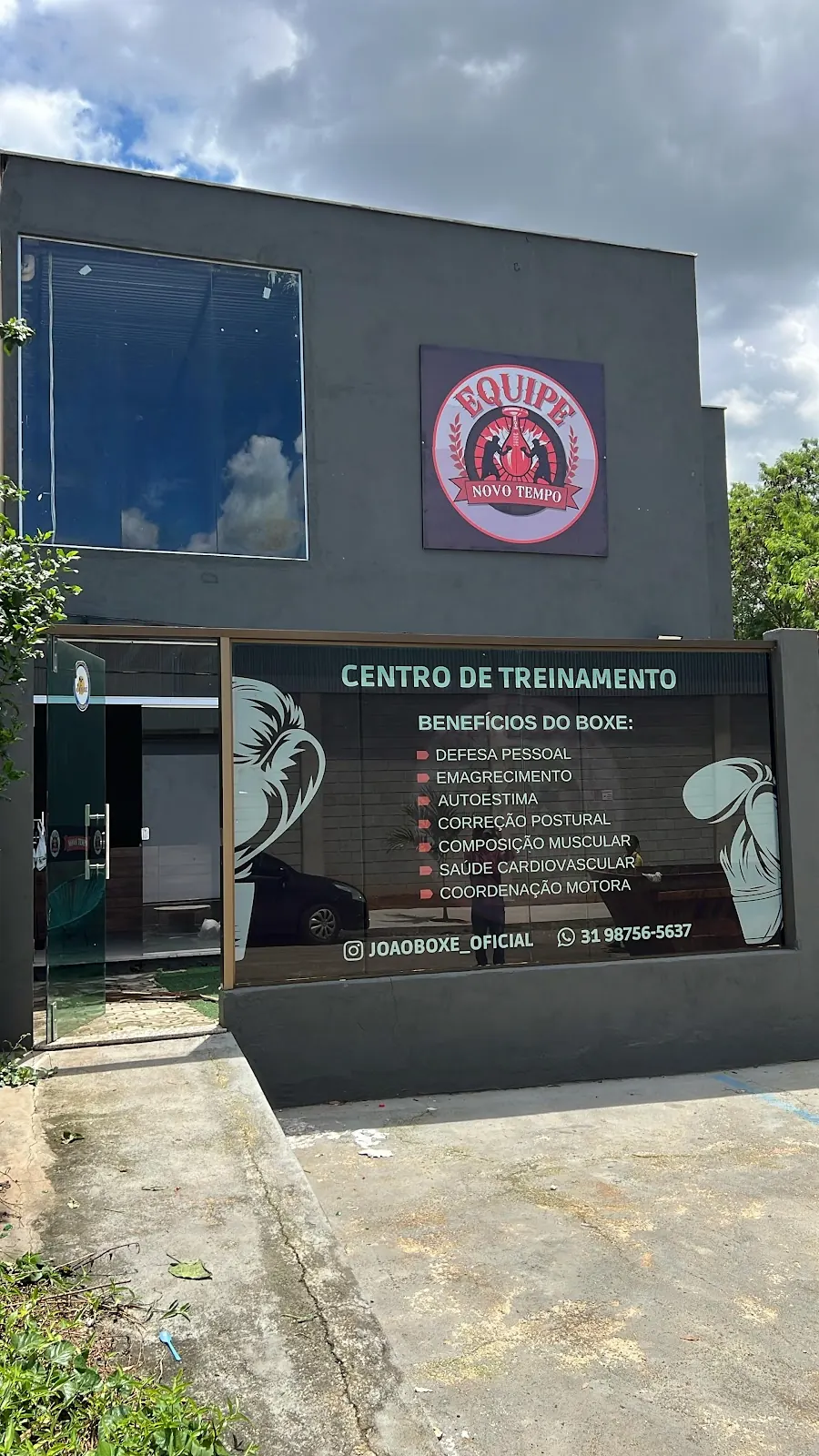 Fachada do Centro de Treinamento Novo Tempo, com o emblema da equipe e a vitrine dos benefícios do boxe